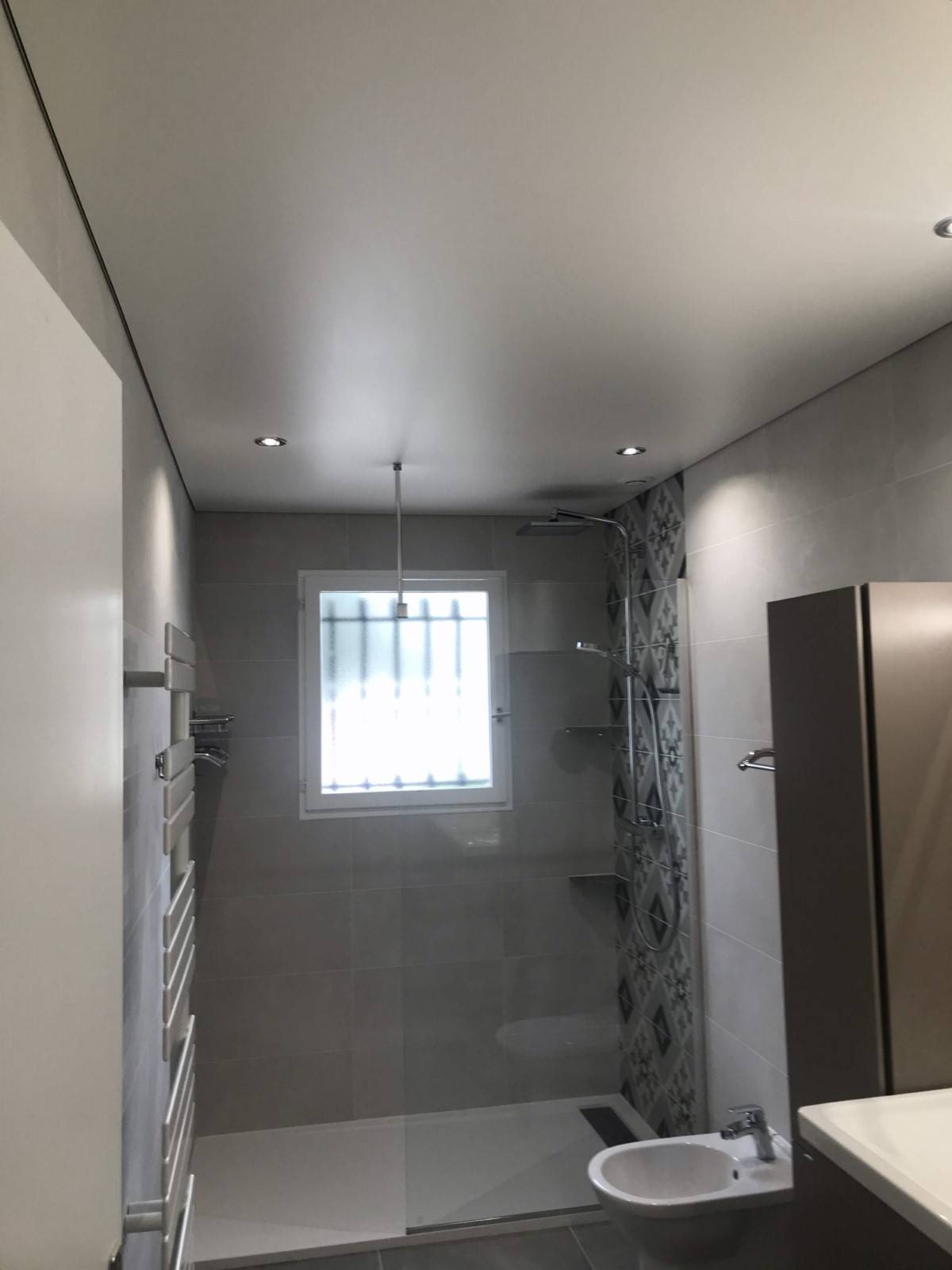Plafond tendu dans une salle de bains Pose de faux plafonds en toile tendue et toile murale à